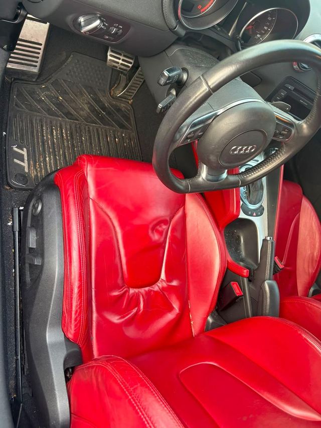 Audi TT driver footwell before detailing: gritty rubber mats and dusty pedals